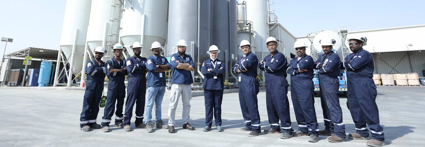 The Superior Cementing team standing outside of its Kuwait facilty posing together with their arms crossed