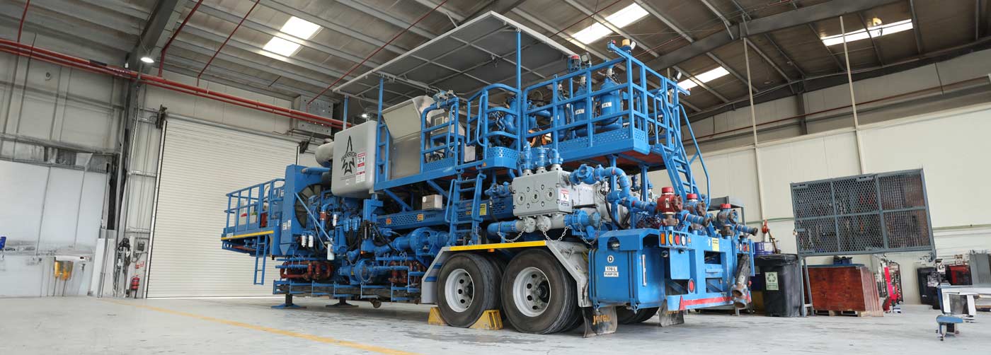 A blue Superior Cementing cementing unit parked in a garage