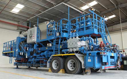 A blue Superior Cementing cementing unit parked in a garage